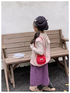 Borsa a tracolla rossa a pois per bambina con fiocco bianco su outfit autunnale