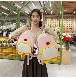 Gros plan du sac à dos pingouin rose avec breloque en peluche dans une boutique fleurie