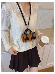 Detail of a brown corduroy mini bucket bag with leather handles and bow accents