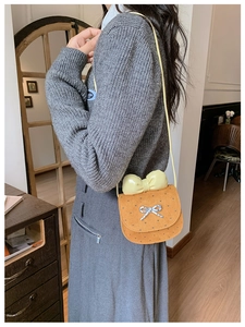 Borsa a tracolla arancione da bambina con cuori e fiocco giallo sulla modella