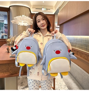Détail de sacs à dos en forme de pingouin bleu clair avec pendentifs pour étudiantes