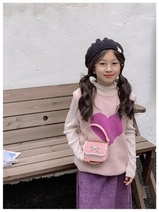 Vue détaillée du sac rose pour enfant avec nœud, dentelle et bandoulière chaîne