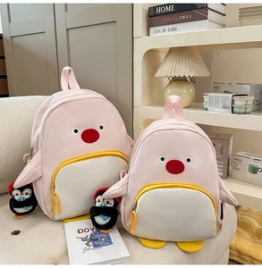 Vue détaillée de deux sacs à dos pingouin roses de tailles variées avec porte-clés