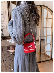 Détail du mini sac rouge pour filles avec bordure en dentelle blanche et nœud argenté