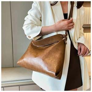 Close-up of deep brown leather tote bag with glossy texture and minimalist commute style