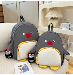 Détail du sac à dos pingouin mignon avec son porte-clés en peluche et poche avant