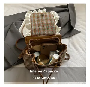 Internal capacity of the vintage plaid backpack showing storage for phone and cosmetics