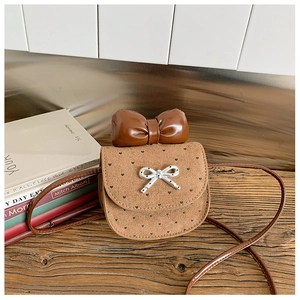 Dettaglio della mini borsa a tracolla marrone con motivo a cuori e fiocco grande