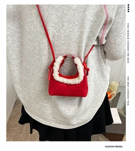 Close-up of mini red suede crossbody bag with white faux fur trim on a model