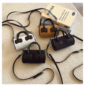 Detail of four colorful corduroy mini bucket bags with bow decor and thin straps