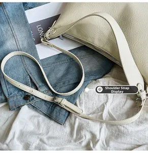 Detail of adjustable strap with metal buckles and silver zipper on off-white tote bag
