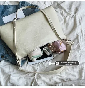Interior view showing the large capacity of a beige hobo bag with daily essentials