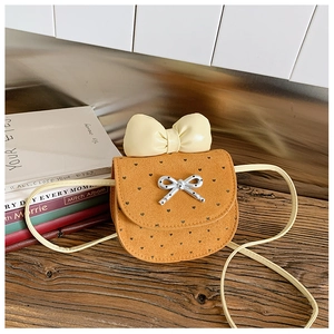 Dettaglio borsa a tracolla arancione per bambini con fiocco giallo e motivi a cuore