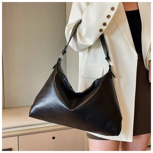 Detail of soft black leather hobo bag with adjustable silver buckle and glossy texture