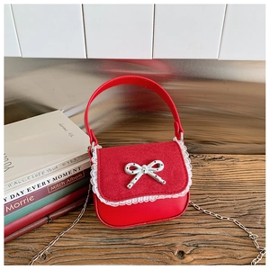Détail du sac à main rouge pour enfant avec dentelle et boucle de nœud à pois