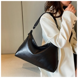 Detail showing high-gloss wrinkled leather texture of black hobo bag with silver ring hardware