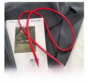 Close-up of red leather shoulder strap with white faux fur detail on dumpling bag