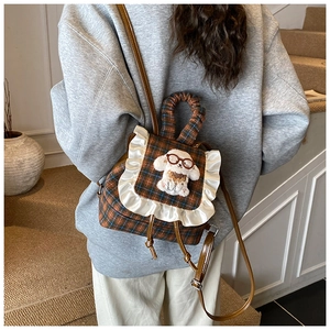 Detailed view of checkered plaid kids backpack featuring lace trim and 3D plush puppy decor