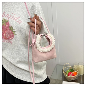 Détail du mini sac à main rose en suédine avec poignée décorative en polaire blanche
