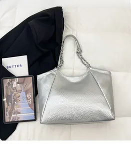 Detail of silver metallic hobo bag with litchi texture and elegant chain shoulder strap