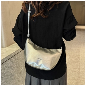 Detailed back view of a silver metallic hobo bag worn as a stylish underarm shoulder bag