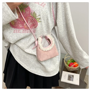 Détail du mini sac bandoulière rose en daim avec bordure en peau de mouton et sangle