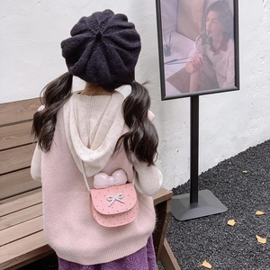 Borsa a tracolla rosa per bambini con fiocco decorativo mostrata in esterno alla moda