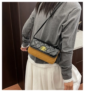 Detail of color-block quilted shoulder bag with gold clasp and textured matte finish
