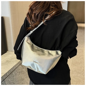 Silver metallic hobo bag on shoulder with subtle textured crackle finish and metal logo