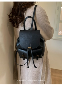 Detail eines schwarzen Retro-Lederrucksacks für Damen mit Gold-Schnallen und Vordertaschen