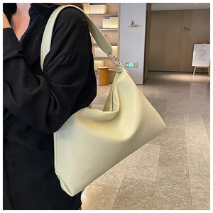 Detailed side view of cream white tote bag with textured faux leather and shoulder strap