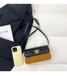 Detail of crossbody bag with black quilted flap and brown suede body featuring gold lock