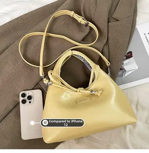 Detailed view of cream leather shoulder bag with knot handle and striped fabric lining