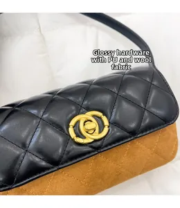 Detail of the golden interlocking lock on a black quilted PU and brown wool bag