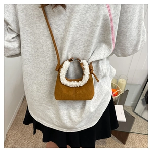 Dettaglio della mini borsa in camoscio marrone con morbido bordo in shearling sintetico
