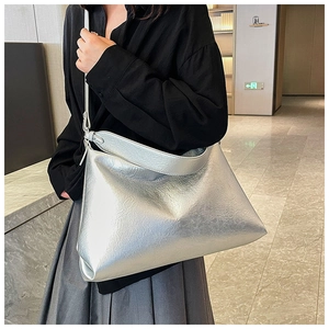 Detail of silver metallic tote bag featuring natural pleated texture and glossy finish