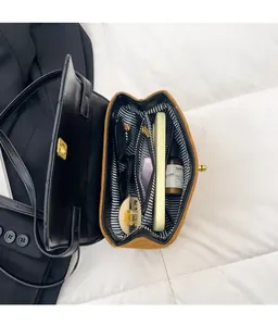 Internal view of brown crossbody bag showing striped lining and multi-compartment storage
