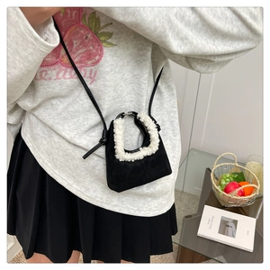 Mini sac à bandoulière noir avec bordure en fausse fourrure blanche sur sweat gris