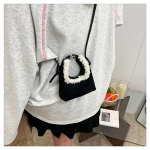 Mini borsa in pelle scamosciata nera con manici in pelliccia sintetica bianca e tracolla