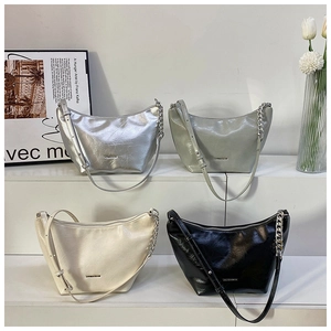 Detail of four hobo bags in silver, green, cream, and black on a white display