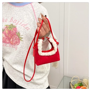Détail du mini sac à main en daim rouge avec poignée en fausse fourrure blanche