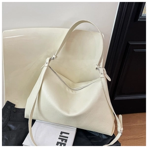 Detail of minimalist cream white PU leather tote bag with smooth texture and sturdy handles