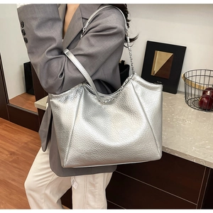 Silver metallic leather tote bag with chain strap shown on model for city style