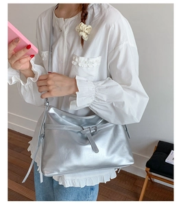 Silver metallic tote bag shown on model with white shirt and jeans for casual look