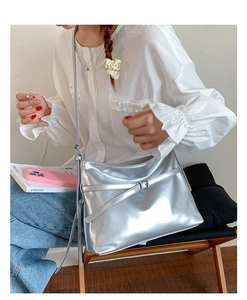 Detail of silver metallic PU tote bag featuring buckle design and long shoulder strap