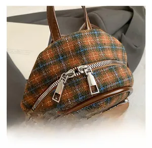 Close-up of the silver double metal zippers on the mini plaid tweed toddler backpack