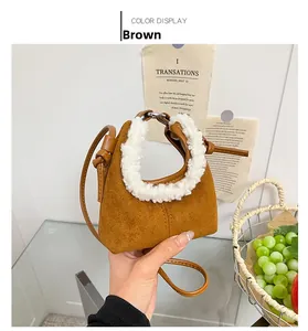 Close-up of brown suede mini handbag with soft white plush handle and shoulder strap