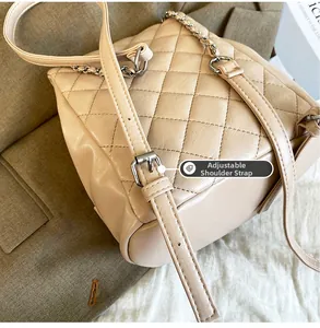 Détail de la bandoulière réglable avec boucle argentée sur sac à dos matelassé beige
