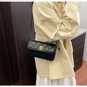 Close-up of quilted leather crossbody bag with iconic gold interlocking buckle detail