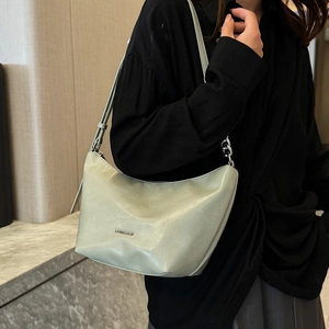 Green minimalist crescent underarm bag with silver chain strap shown on a model
